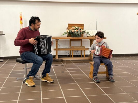 Junger Musiker mit Akkordeon auf der Bühne – Musikunterricht und Konzert Zürich
